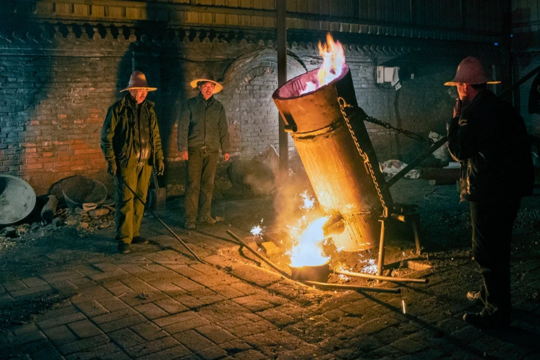 The masters melt the hot iron water used for dashuhua and pour it into the pot